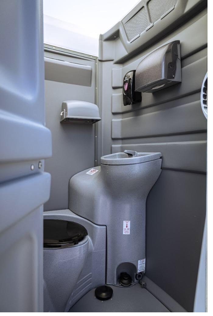 Interior close-up of a clean event restroom unit with fixtures