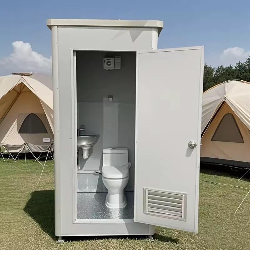 Deluxe restroom unit with open door showing sink and toilet, set up near event tents